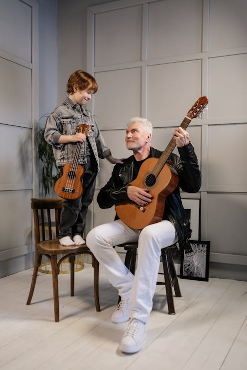 Grandfather and Grandson Holding Their String Instruments while Looking at Each Other