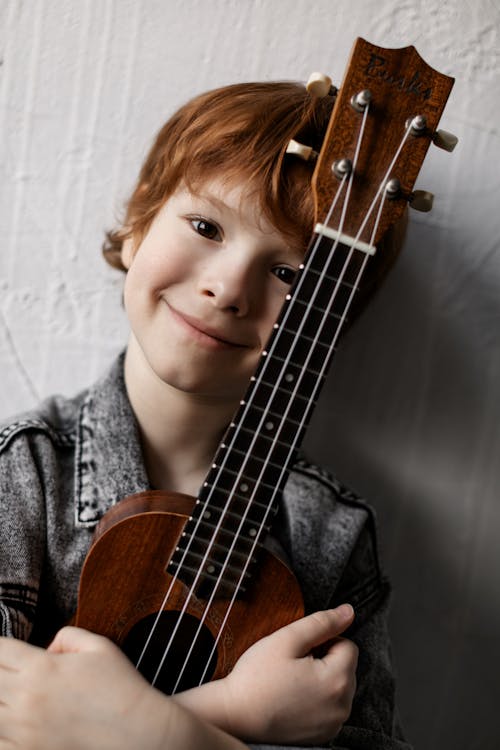 Free Close-Up Photo of a Boy Holding His Ukulele Stock Photo