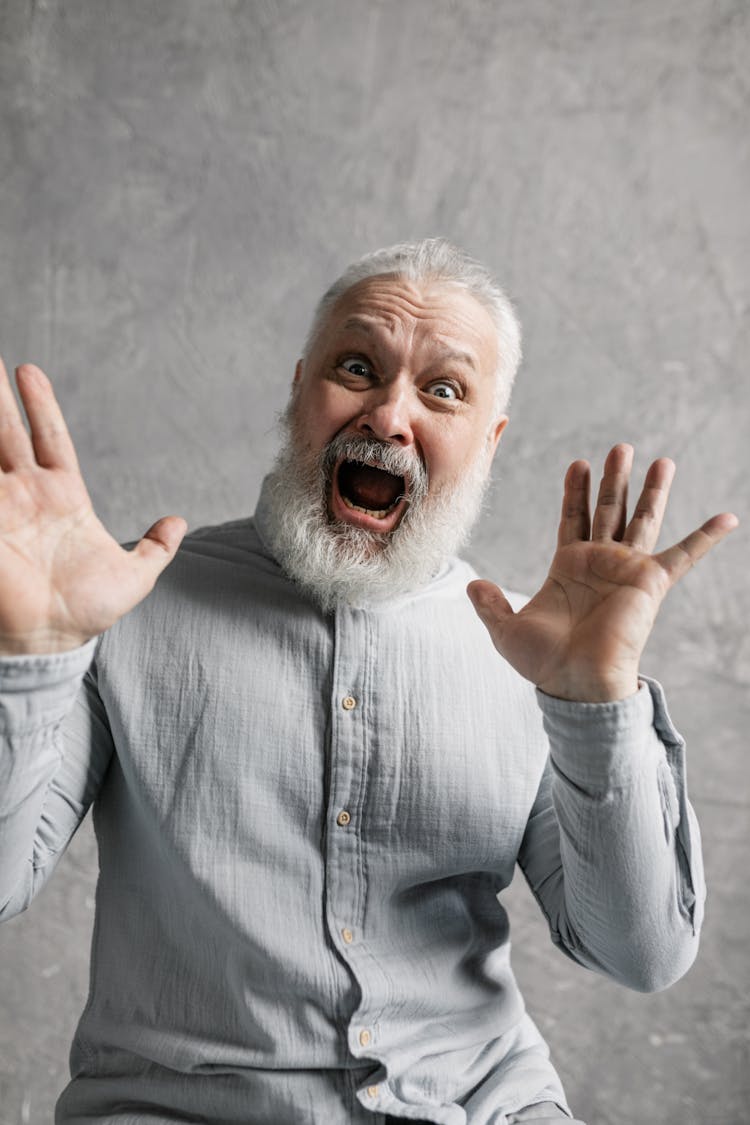 Elderly Man In Gray Long Sleeves Looking Surprised