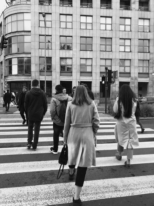 Free People crossing a zebra crossing in Poznań, Poland, in a monochrome city scene. Stock Photo