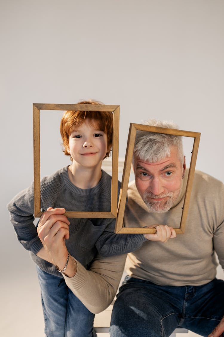 Grandfather And Grandson Having Fun With Frames