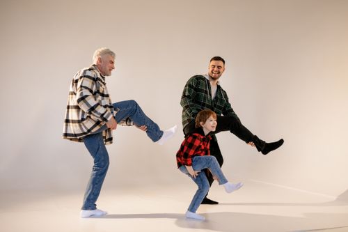 Free Joyful moment with grandfather, father, and son playing together, captured in a bright studio setting. Stock Photo