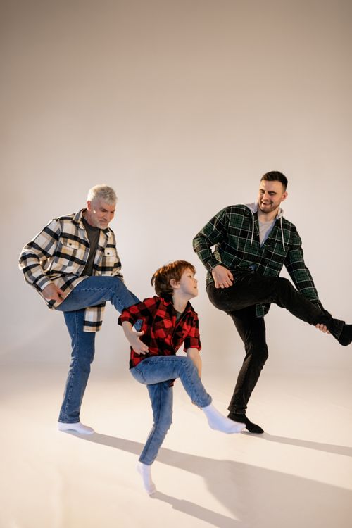 Free Three family members of different ages playing and laughing together indoors. Stock Photo