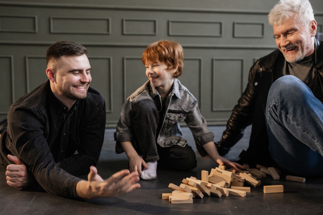 three generations enjoying a playful jenga game indoors capturing happ
