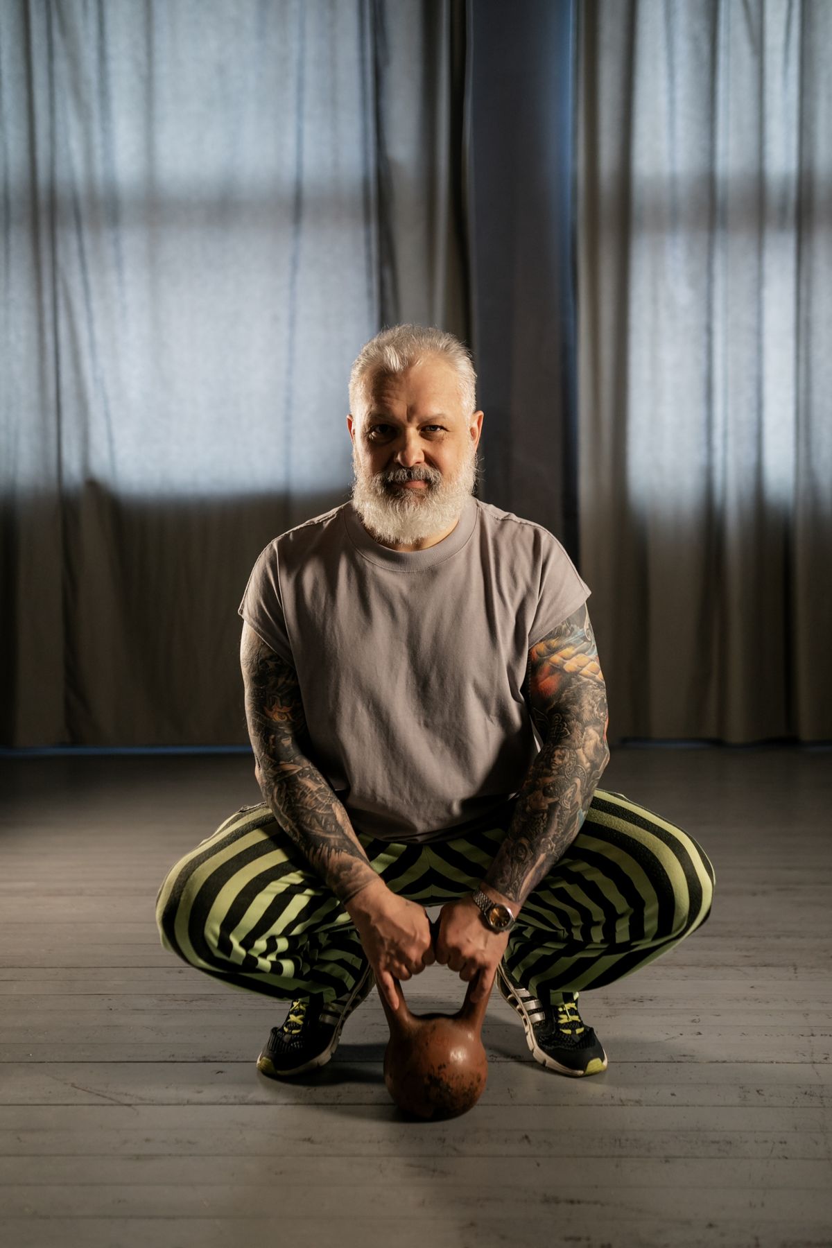 Elderly man holding a kettlebell during a strength training workout