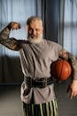 Elderly Man Showing Off His Muscles while Holding a Basketball