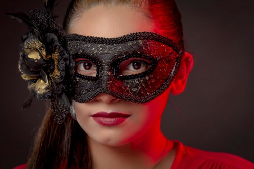 Free Close-up of a woman wearing a detailed masquerade mask with floral embellishments. Stock Photo