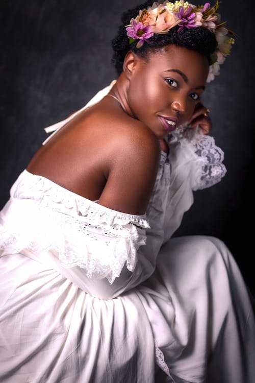 Woman in a White Off-Shoulder Dress Looking at the Camera