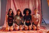Women Posing Together While Kneeling on the Floor