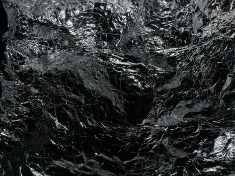 Reflective crumpled silver foil texture, ideal for backgrounds or abstract designs.
