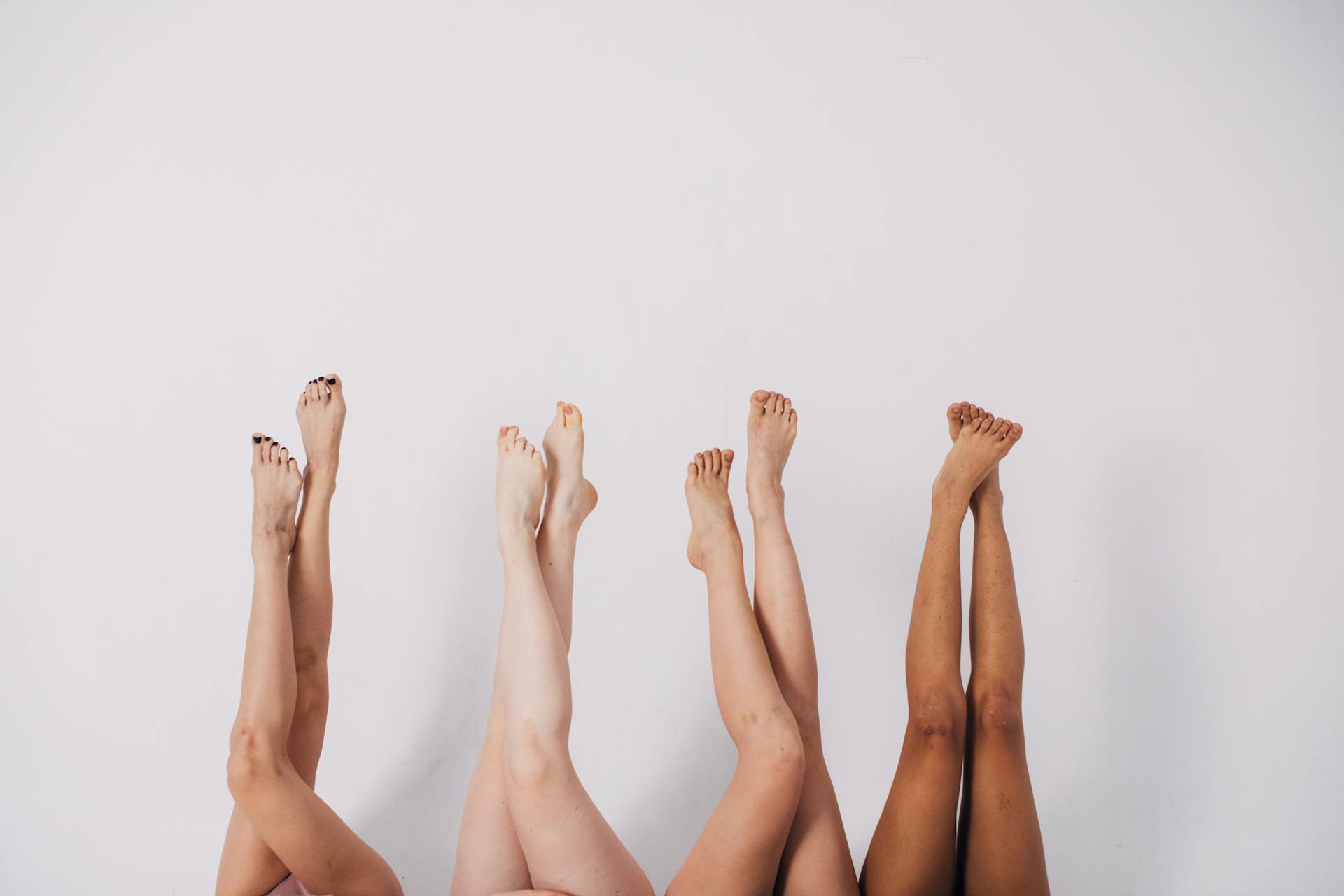 A Group of People Lying Down with Legs Up on Air