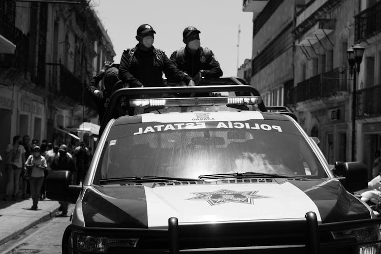 Policemen Standing At The Back Of A Pickup Truck