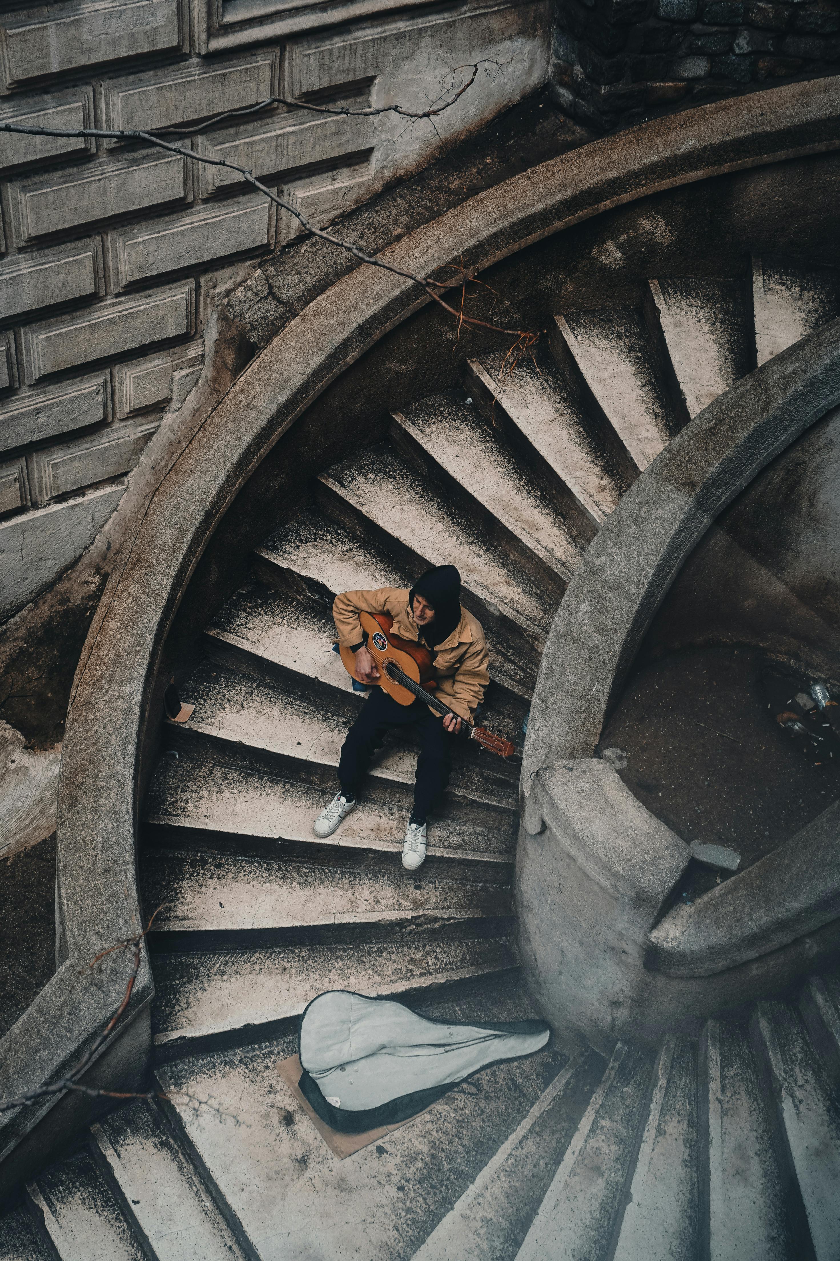 A man playing guitar on the iconic Camondo Stairs in Istanbul, Turkey.