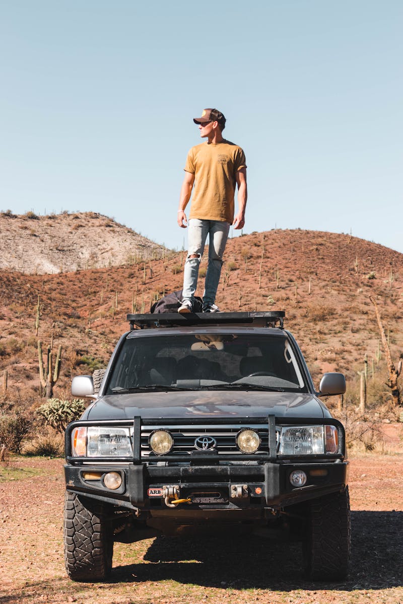 A Man Standing on Top of an Off Road Vehicle