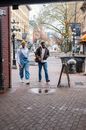 Man in Blue Denim Jeans Standing Beside Woman in White Jacket