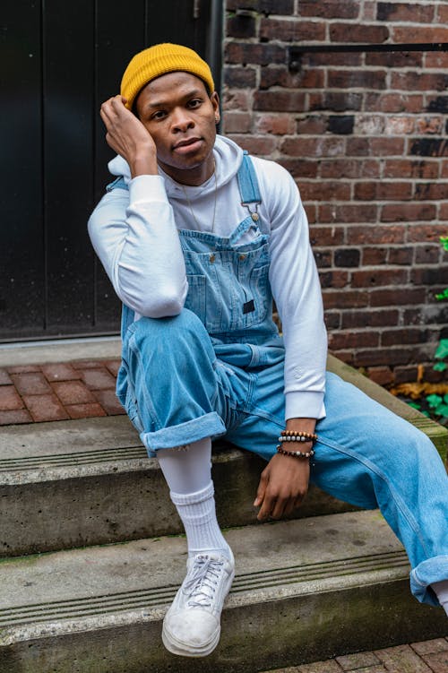 A Male Model in a White Hoodie and Denim Dungarees · Free Stock Photo