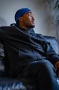 Man in Black Leather Jacket Sitting on Black Couch