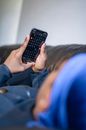 Woman in Blue Long Sleeve Shirt Holding Black Smartphone