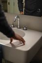 Person in Black Long Sleeve Shirt Holding White Ceramic Sink