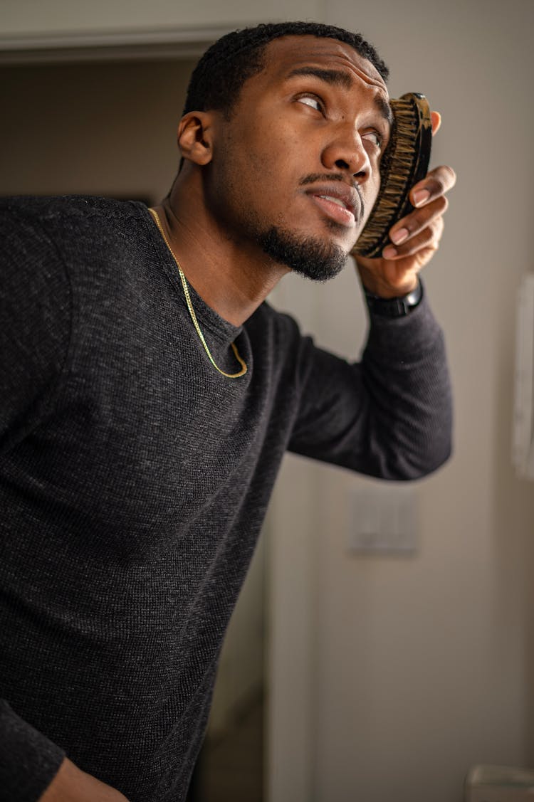 Low Angle View Of A Man Brushing Short Hair