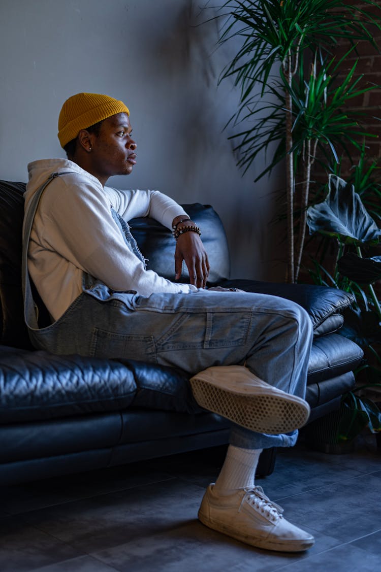 A Man In Overalls Sitting On The Couch 