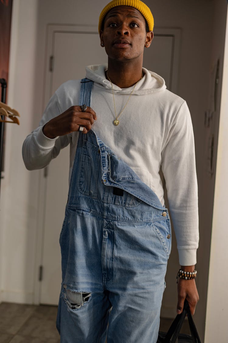 A Man Wearing White Hoodie And Blue Overalls