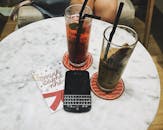 舒适的咖啡馆里，大理石桌上放着两杯冰镇饮料，配有电话和卡片