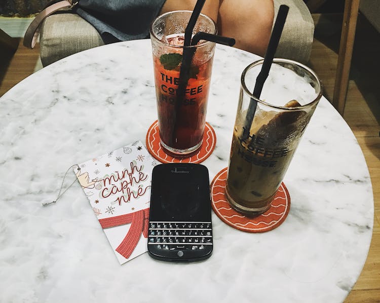 Photo Of Blackberry Phone Beside Two Tall Glasses