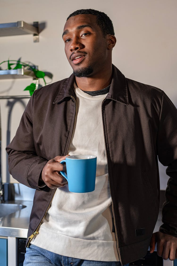 Young Man Drinking Coffee From Cup