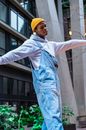 Man in Blue Dress Shirt and Yellow Knit Cap Raising His Right Hand