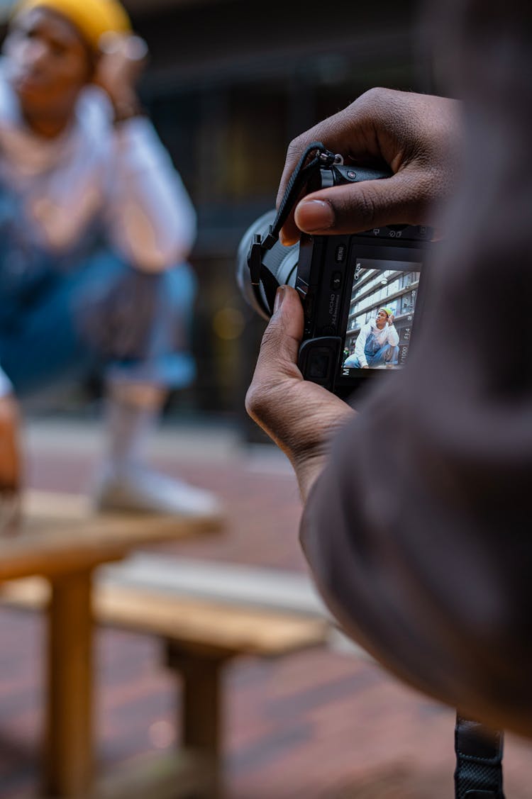 Person Taking Photo On Professional Camera Outdoors