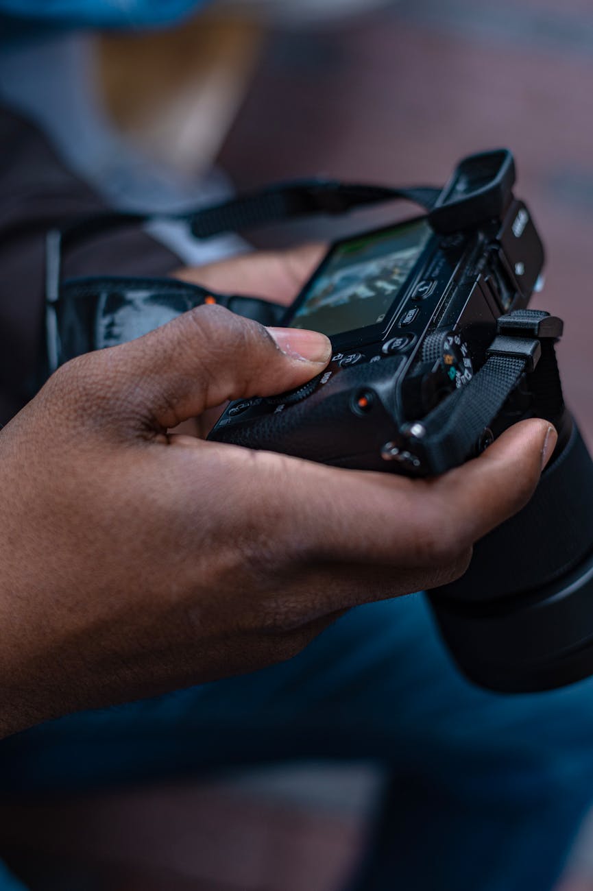 Detailed view of hands holding a digital camera, perfect for photography themes.