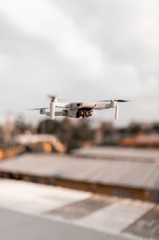 Close-up of a flying drone capturing urban landscape with a blurred background.