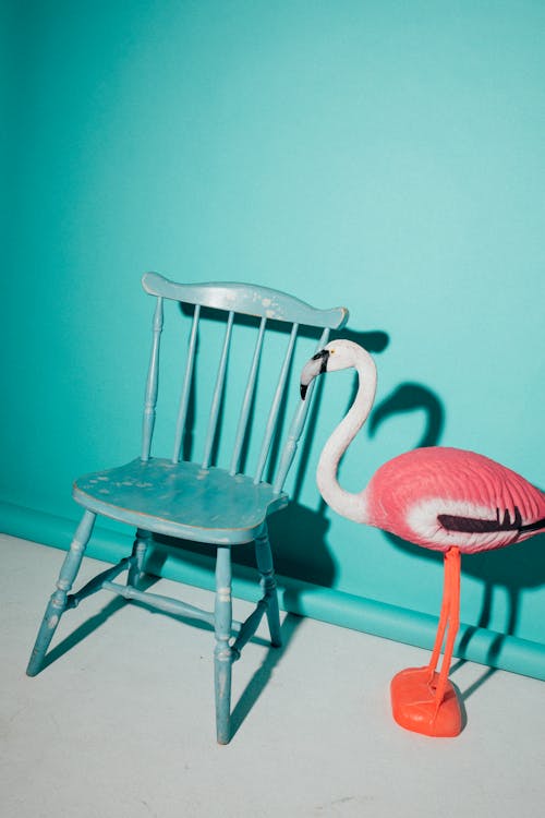 Flamingo Figurine Beside a Wooden Chair