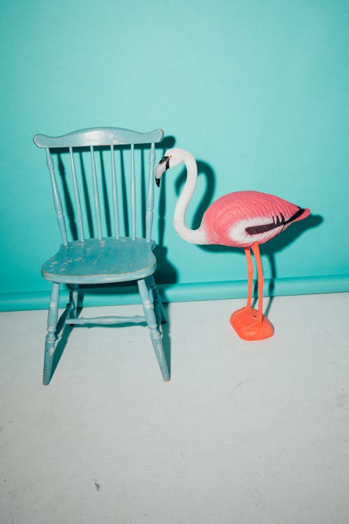Flamingo Figurine Beside a Wooden Chair