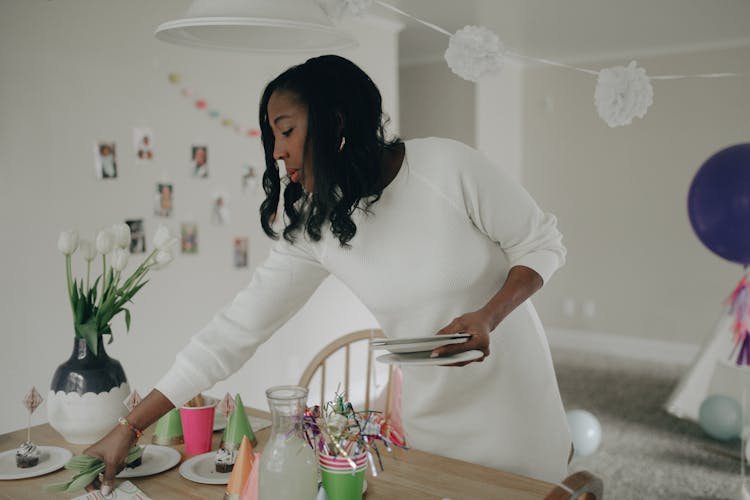 A Woman Setting A Table At A Birthday Party