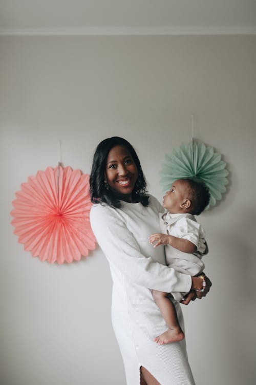 A Woman Smiling while Holding a Baby