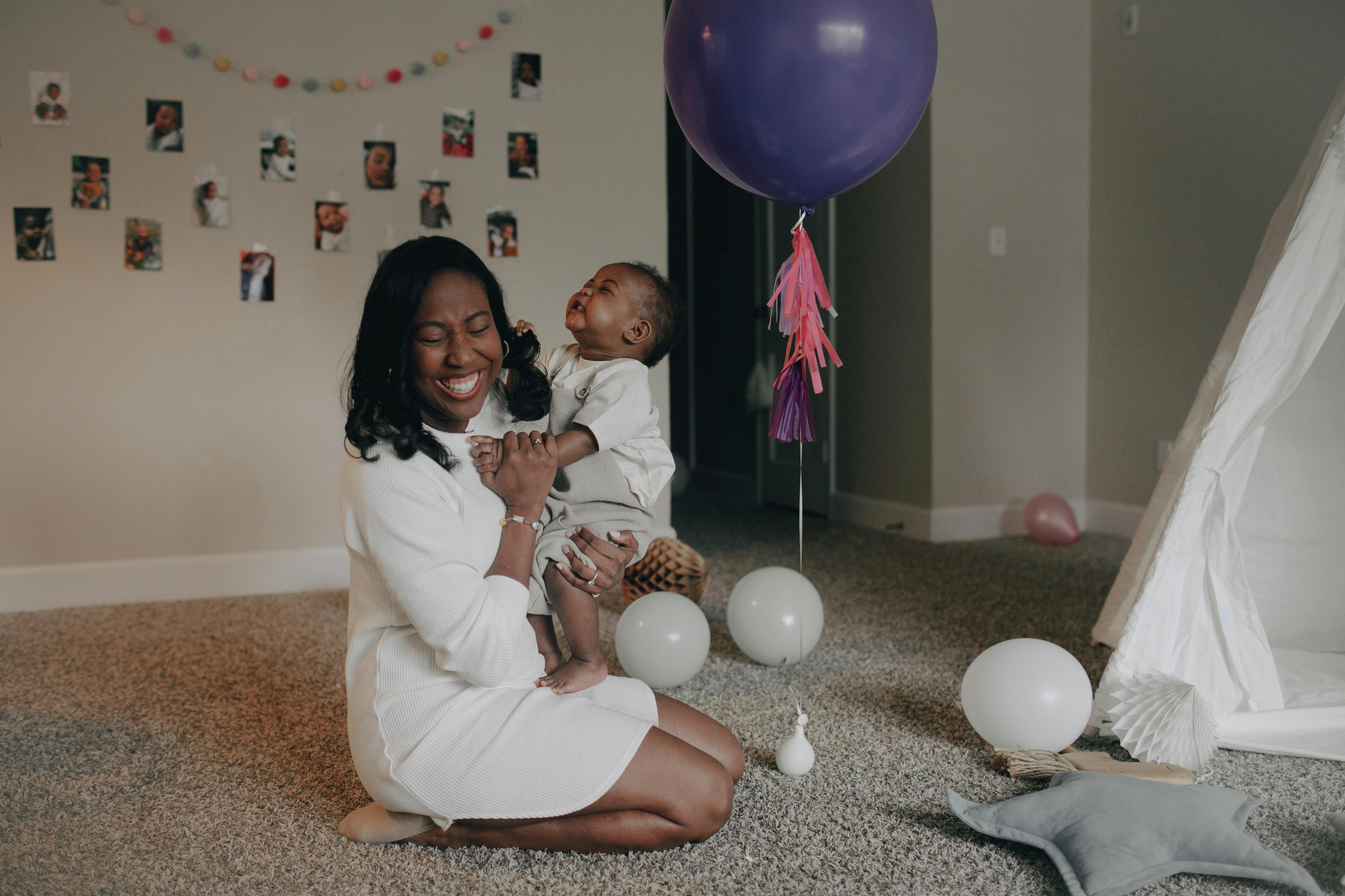 a woman laughing while holding a child