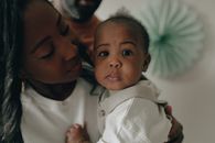 Man in White Button Up Shirt Carrying Baby in White Shirt