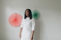 Woman in White Long Sleeve Dress Holding Red Flower Bouquet