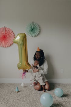 A touching scene of a mother and baby celebrating a first birthday with balloons and decorations.