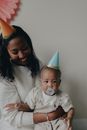Woman in Black Shirt Carrying Baby in White Onesie