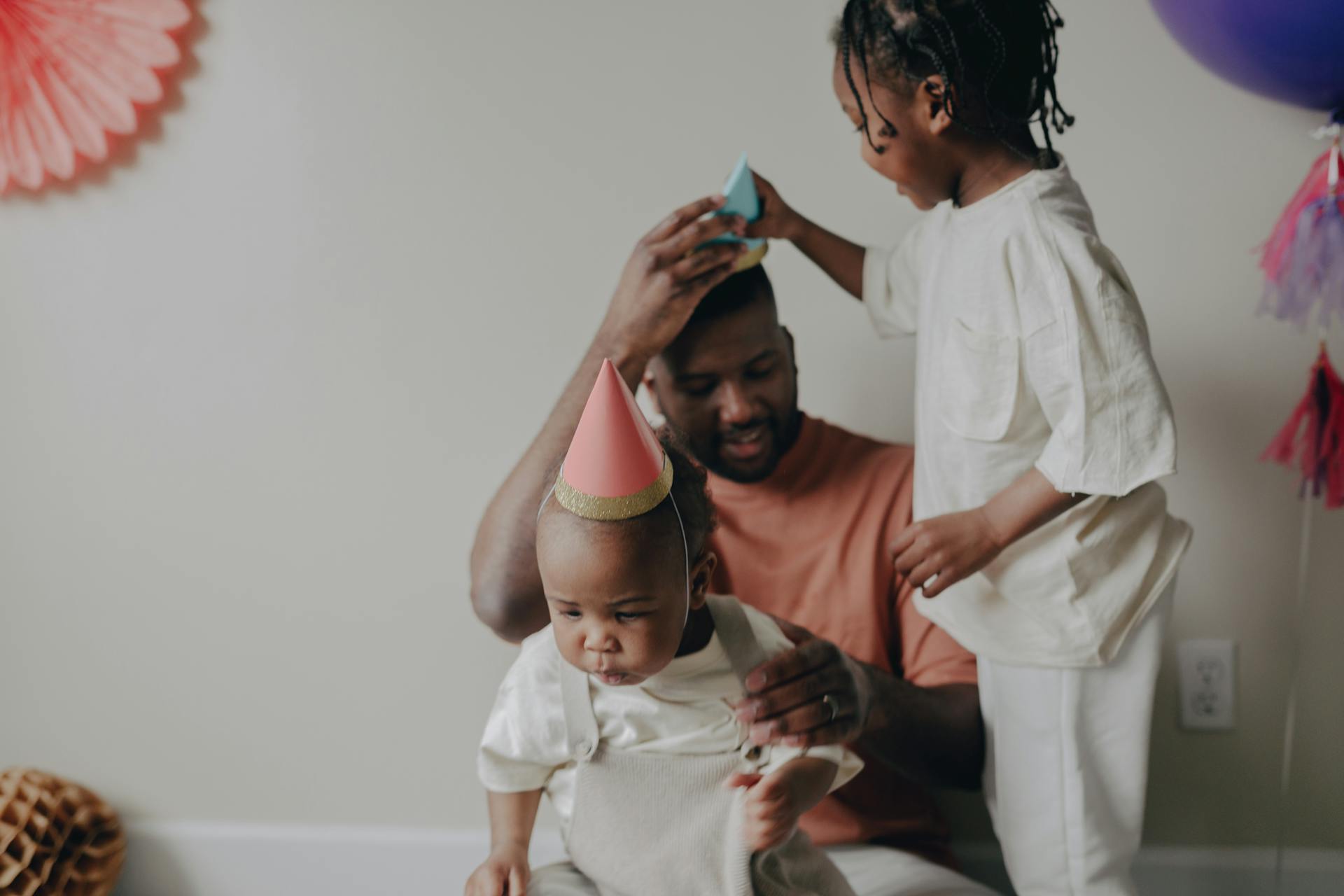 A family celebrating a first birthday with party hats and joyful bonding moments.