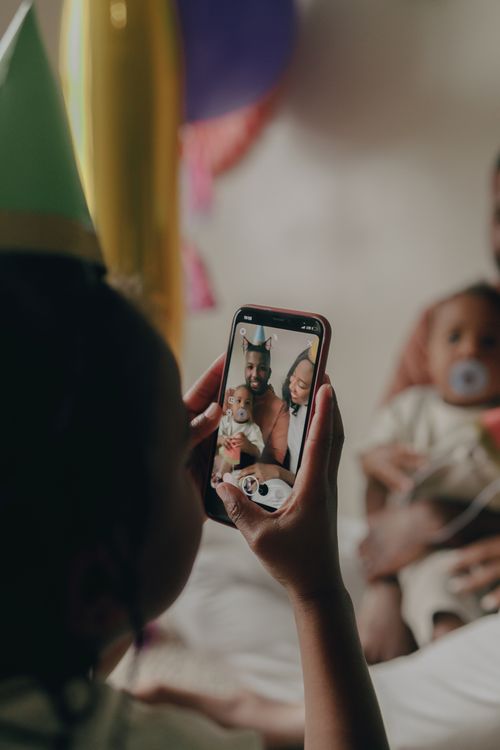 Free A joyful family moment captured on a smartphone during a birthday celebration. Stock Photo