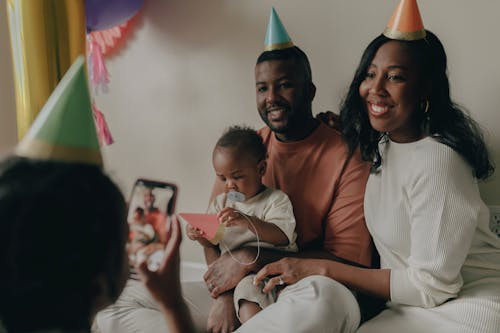 Free A Family with Party Hats Smiling Together Stock Photo