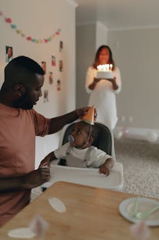 A family celebrates a birthday with cake and candles indoors.