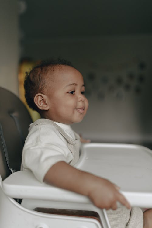 Free Baby Sitting in a High Baby Chair  Stock Photo