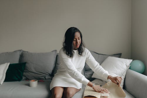 Woman Sitting While Wrapping a Gift 