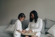 Woman in White Long Sleeve Shirt Sitting Beside Woman in White Long Sleeve Shirt