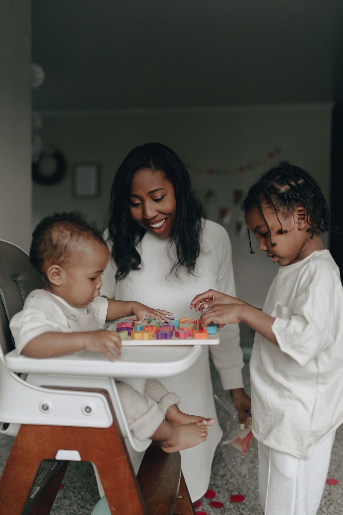 Mother watching children play and learn together with building toys
